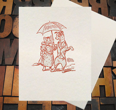 Letterpress Card with an image of a dog and a cat on a date, wearing clothes and carrying an umbrella